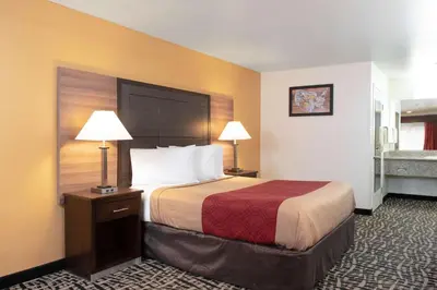 a hotel room with a bed and two lamps at Executive Inn westley,CA in Westley