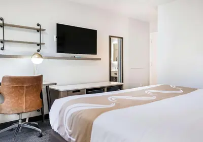 a hotel room with a bed and a desk and a tv at Quality Inn South Lake Tahoe in South Lake Tahoe