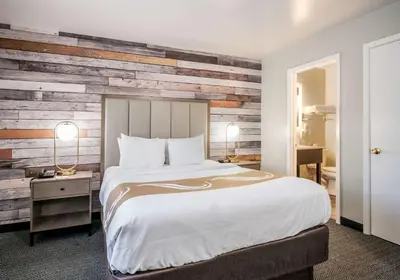 a bedroom with a bed and a wooden wall at Quality Inn South Lake Tahoe in South Lake Tahoe