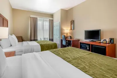 a hotel room with two beds and a flat screen tv at Comfort Inn & Suites Galt - Lodi North in Galt