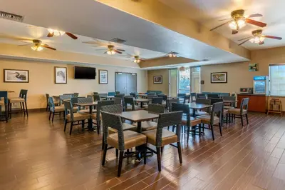 a dining room with tables and chairs and a tv at Comfort Inn & Suites Galt - Lodi North in Galt
