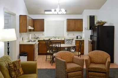 a kitchen with a refrigerator and a table and chairs at Quality Inn Yosemite Valley Gateway in Mariposa