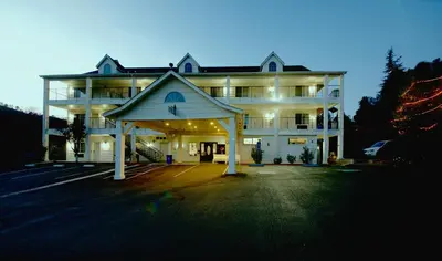 a large white building with a lit up garage at Quality Inn Yosemite Valley Gateway in Mariposa