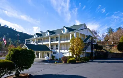 a large white building with a flag in front of it at Quality Inn Yosemite Valley Gateway in Mariposa