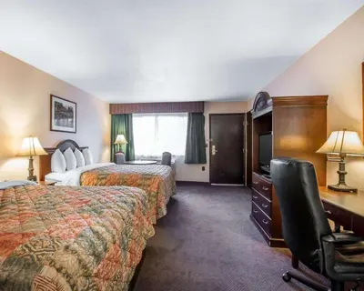 a hotel room with two beds and a desk at Quality Inn & Suites Cameron Park Shingle Springs in Cameron Park