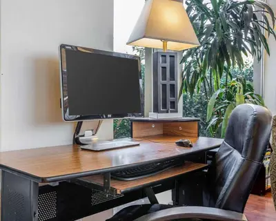a computer monitor sitting on a desk with a chair at Quality Inn & Suites Cameron Park Shingle Springs in Cameron Park