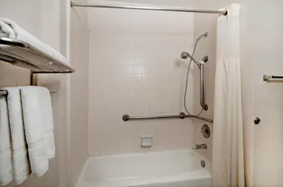 a white bathroom with a shower and a white tub at Quality Inn & Suites South San Jose - Morgan Hill in Morgan Hill