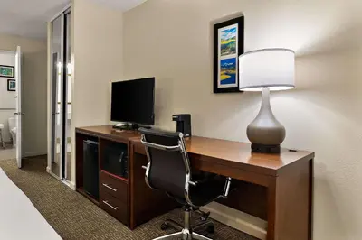 a room with a desk with a television and a lamp at Comfort Inn & Suites Sequoia Kings Canyon in Three Rivers