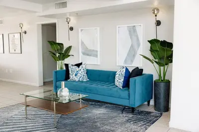 a blue couch in a living room with a glass table at Quality Inn & Suites Lathrop in Lathrop