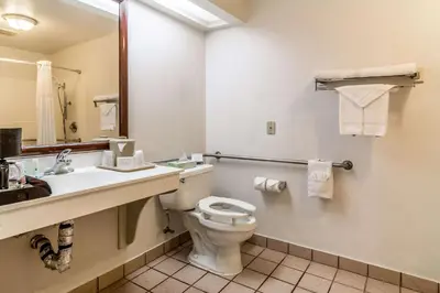 a bathroom with a toilet and a sink and a mirror at Quality Inn Fresno Near University in Fresno