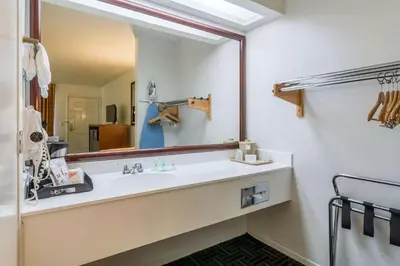 a bathroom with a sink and a large mirror at Quality Inn Fresno Near University in Fresno