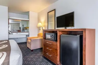 a hotel room with a bed and a flat screen tv at Quality Inn Fresno Near University in Fresno