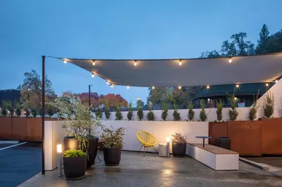 a patio with a white canopy and potted plants at Hotel Lumberjack - Sonora in Sonora