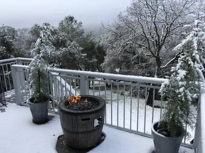 a fire pit on a balcony in the snow at Papillon Cellars - The Loft in Mariposa