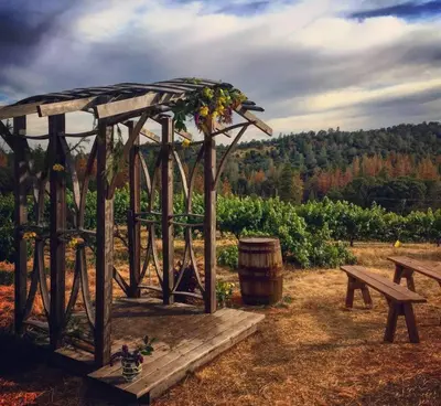 a wooden gazebo with a barrel and a bench at Papillon Cellars - The Loft in Mariposa