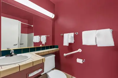 a red bathroom with a toilet and a sink at Econo Lodge Fallon Naval Air Station Area in Fallon