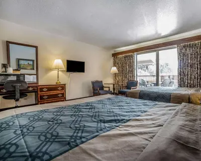 a hotel room with a bed and a desk and a window at Econo Lodge Near Reno-Sparks Convention Center in Reno