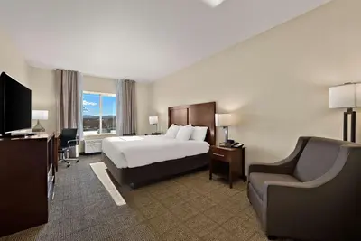 a hotel room with a bed and a chair at Comfort Inn & Suites Airport Convention Center in Reno