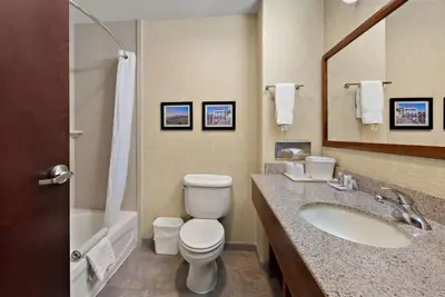 a bathroom with a toilet and a sink and a mirror at Comfort Inn & Suites Airport Convention Center in Reno