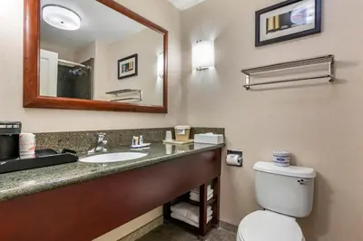a bathroom with a sink and a toilet and a mirror at Comfort Suites Fernley in Fernley
