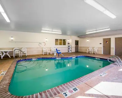 a pool in a large room with chairs and a table at Comfort Suites Fernley in Fernley