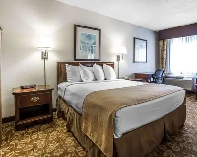 a hotel room with a large bed and a desk at Quality Inn & Suites Minden in Minden