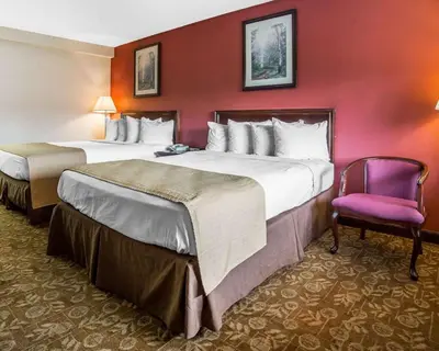 a hotel room with two beds and a purple chair at Quality Inn & Suites Minden in Minden