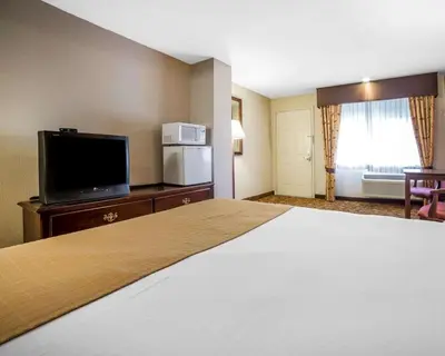 a hotel room with a bed and a flat screen tv at Quality Inn & Suites Minden in Minden