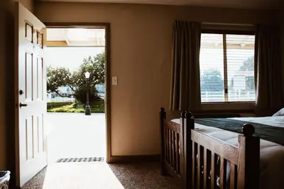 a bedroom with a crib and a large window at Wonder Valley Ranch Resort in Pine Flat Lake