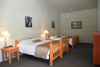 two beds in a room with two lamps and two tables at Wonder Valley Ranch Resort in Pine Flat Lake