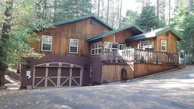 a large wooden house with a balcony and a garage at Winterfell Inn - No Xtra Fees, Dogs OK, King & Queen Suites in Arnold