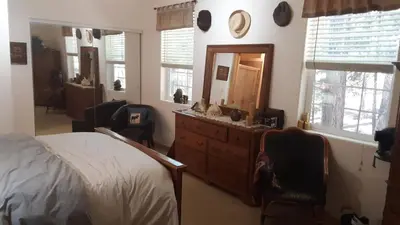 a bedroom with a bed and a dresser and a mirror at Winterfell Inn - No Xtra Fees, Dogs OK, King & Queen Suites in Arnold