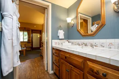 a bathroom with two sinks and a mirror at Olympic Village Inn Olympic Valley in Olympic Valley