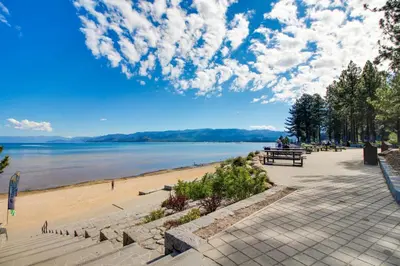 a beach with people sitting on a bench next to the water at Take me back to Talbot in South Lake Tahoe