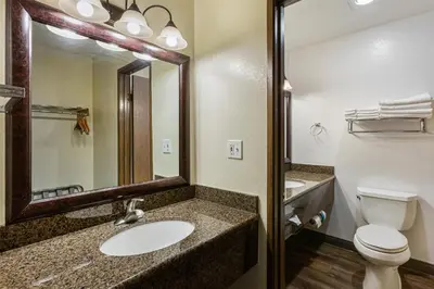 a bathroom with a sink and a toilet and a mirror at Best Western Hi-Desert Inn in Tonopah