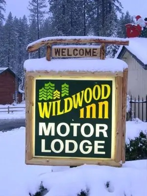 a sign for a wildwood im motor lodge in the snow at Wildwood Inn in Twain Harte