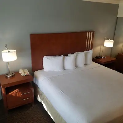 a hotel room with a bed with white sheets and pillows at SureStay Hotel by Best Western Hollister in Hollister