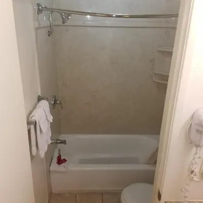 a bathroom with a white tub and a toilet at SureStay Hotel by Best Western Hollister in Hollister