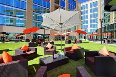 a courtyard with couches and umbrellas in a building at University Plaza Waterfront Hotel in Stockton