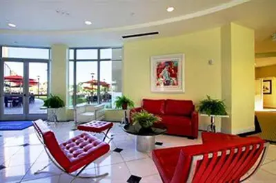 a living room with red chairs and a red couch at University Plaza Waterfront Hotel in Stockton