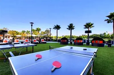 a ping pong table in a park with palm trees at University Plaza Waterfront Hotel in Stockton