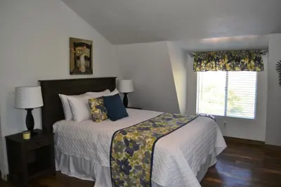 a bedroom with a large bed and a window at The Quail's Nest in Three Rivers