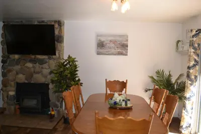 a dining room with a table and a fireplace at The Quail's Nest in Three Rivers