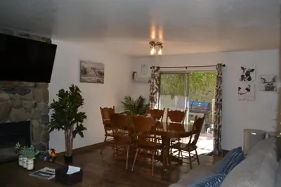 a living room with a table and chairs and a fireplace at The Quail's Nest in Three Rivers