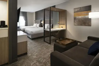 a hotel room with two beds and a living room at Hotel Vista Sierra in Auburn