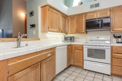 a kitchen with white appliances and wooden cabinets at Snowcreek IV 588 in Mammoth Lakes