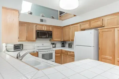 a kitchen with wooden cabinets and a white refrigerator at Snowcreek IV 588 in Mammoth Lakes