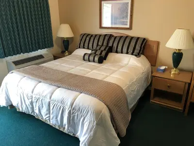 a bedroom with a bed and two lamps and a window at Meadowcliff Lodge Coleville in Coleville