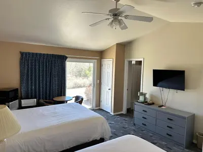 a bedroom with a bed and a flat screen tv at Meadowcliff Lodge Coleville in Coleville