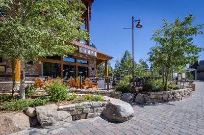 a patio with chairs and trees and a building at Village 3211 in Mammoth Lakes